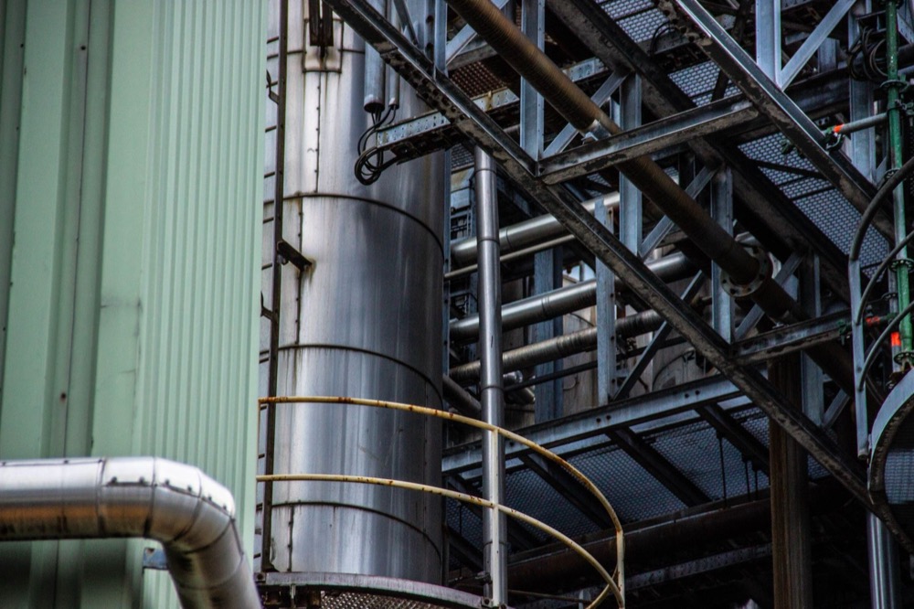 Process piping and a column inside a manufacturing plant.
